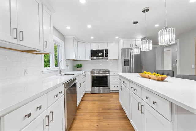 65 Sanborn St, Laconia, NH 03246 - kitchen with stainless steel appliances, a sink, white cabinetry, tasteful backsplash, and light countertops