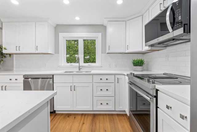 65 Sanborn St, Laconia, NH 03246 - kitchen with appliances with stainless steel finishes, a sink, white cabinets, light wood finished floors, and recessed lighting