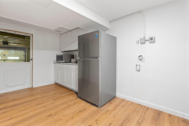 65 Sanborn St, Laconia, NH 03246 - kitchen with stainless steel appliances, light wood finished floors, white cabinets, and baseboards