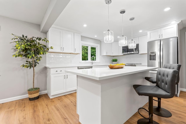 65 Sanborn St, Laconia, NH 03246 - kitchen with stainless steel appliances, a kitchen bar, white cabinets, and recessed lighting