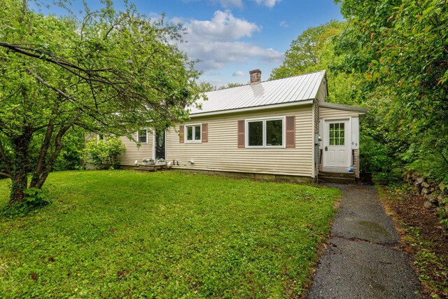 65 Sanborn St, Laconia, NH 03246 - rear view of property with a chimney, a yard, metal roof, and entry steps
