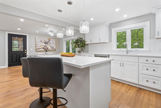 65 Sanborn St, Laconia, NH 03246 - kitchen featuring a sink, light countertops, decorative backsplash, recessed lighting, and a kitchen breakfast bar