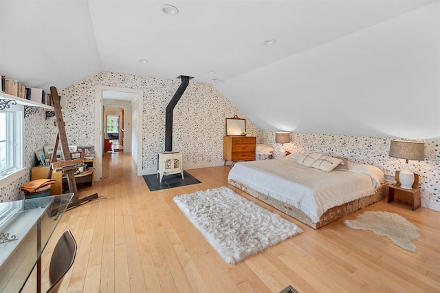 2192 Jack Hill Rd, Calais, VT 05650 - bedroom featuring wallpapered walls, vaulted ceiling, wood-type flooring, and a wood stove