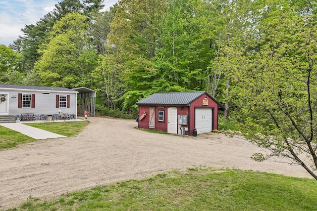 29 Stoneham Rd Unit 4, Wakefield, NH 03872 - view of front facade with dirt driveway, an outbuilding, a detached garage, a carport, and entry steps