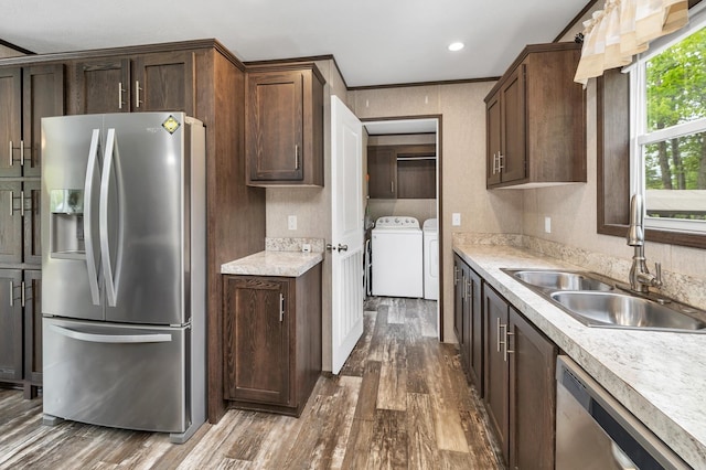 29 Stoneham Rd Unit 4, Wakefield, NH 03872 - kitchen with stainless steel appliances, a sink, washing machine and dryer, dark wood-style flooring, and light countertops