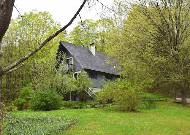 191 Highland Rd, Wallingford, VT 05773 - view of side of home with a chimney, a balcony, roof with shingles, and a yard