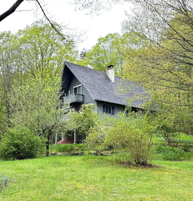 191 Highland Rd, Wallingford, VT 05773 - view of side of property featuring a balcony, a chimney, a shingled roof, and a yard