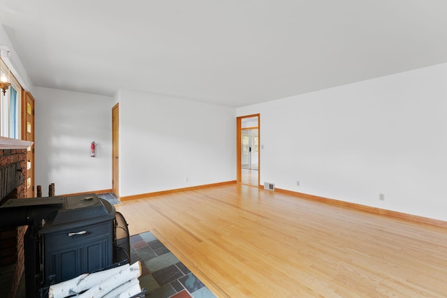 33 Wildwood Dr, Burlington, VT 05408 - unfurnished living room with wood finished floors, a fireplace, and baseboards