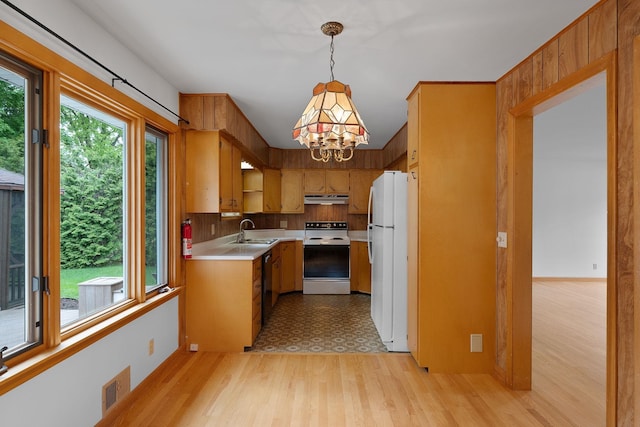 33 Wildwood Dr, Burlington, VT 05408 - kitchen featuring white appliances, under cabinet range hood, light countertops, a chandelier, and a sink
