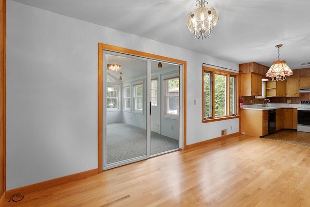 33 Wildwood Dr, Burlington, VT 05408 - kitchen with a chandelier, dishwasher, light countertops, white electric range, and light wood-style flooring