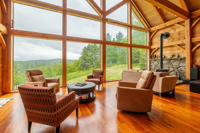 938 Stigers Rd, Andover, VT 05143 - living area with a wood stove, healthy amount of natural light, high vaulted ceiling, hardwood / wood-style floors, and wood ceiling with exposed beams