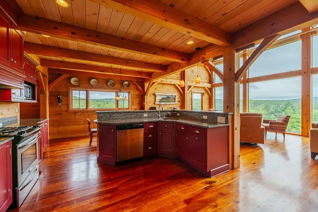 938 Stigers Rd, Andover, VT 05143 - kitchen with appliances with stainless steel finishes, dark wood-type flooring, wooden walls, dark brown cabinets, and hanging light fixtures