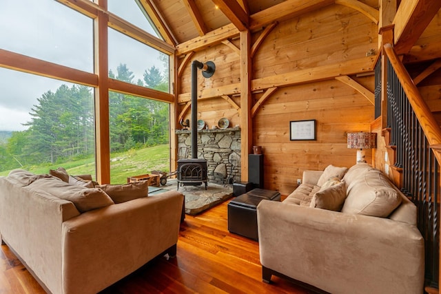 938 Stigers Rd, Andover, VT 05143 - living area with a wood stove, healthy amount of natural light, wooden ceiling with exposed beams, wooden walls, and hardwood / wood-style floors