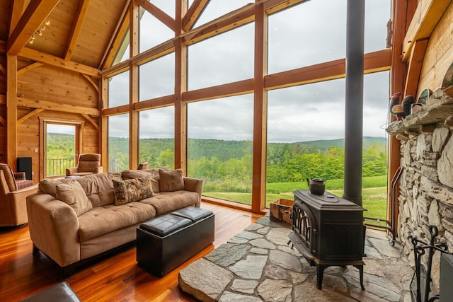 938 Stigers Rd, Andover, VT 05143 - living room with high vaulted ceiling, wood finished floors, wooden ceiling with exposed beams, wooden walls, and a wood stove