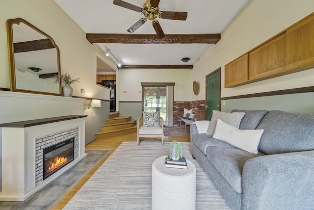 3 Timber Ln, Merrimack, NH 03054 - living area featuring light wood finished floors, beamed ceiling, ceiling fan, a glass covered fireplace, and stairway