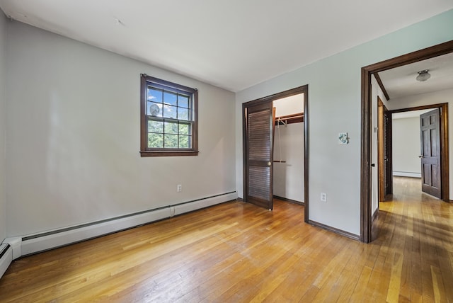 3 Timber Ln, Merrimack, NH 03054 - unfurnished bedroom with light wood-style flooring, a baseboard heating unit, a baseboard radiator, baseboards, and a closet