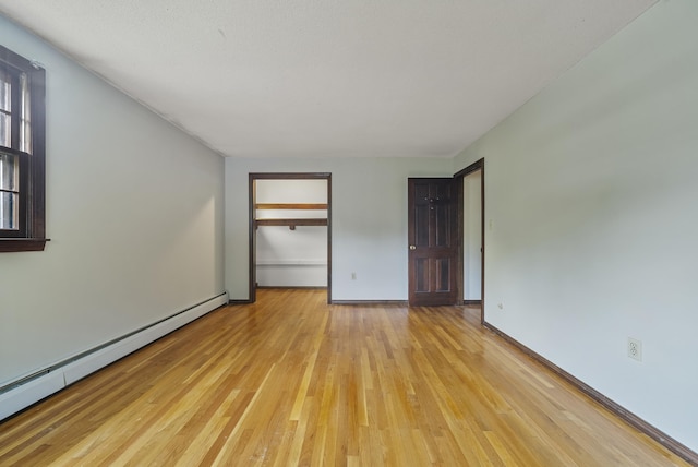 3 Timber Ln, Merrimack, NH 03054 - unfurnished bedroom with a baseboard heating unit, light wood-style floors, a closet, and baseboards