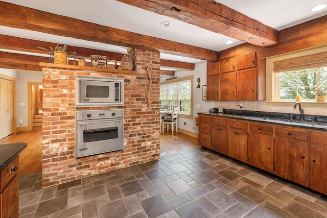 74 Bartlett Rd, Barnstead, NH 03225 - kitchen with appliances with stainless steel finishes, baseboards, dark countertops, beam ceiling, and a sink