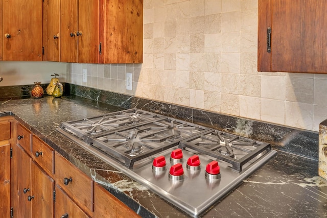 74 Bartlett Rd, Barnstead, NH 03225 - kitchen view of stainless steel gas cooktop, backsplash, and brown cabinetry