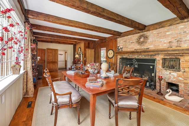 74 Bartlett Rd, Barnstead, NH 03225 - dining space with a brick fireplace, wood finished floors, beam ceiling, and wood walls