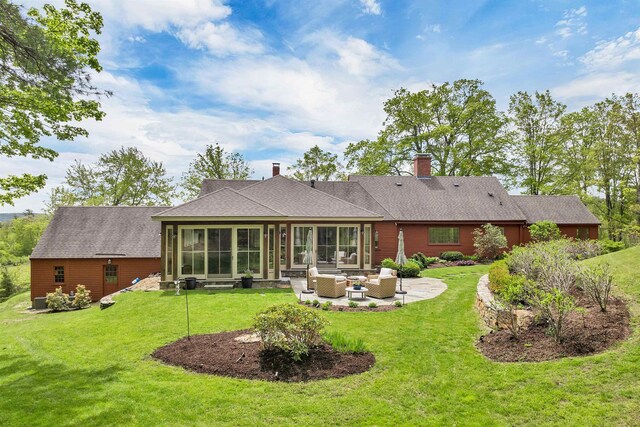 74 Bartlett Rd, Barnstead, NH 03225 - back of house featuring outdoor lounge area, a chimney, a yard, a patio, and a sunroom