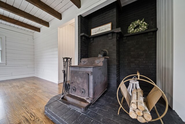 753 Sanborn Rd, Sanbornton, NH 03269 - detailed view of wood finished floors, a wood stove, wooden walls, and wooden ceiling with exposed beams