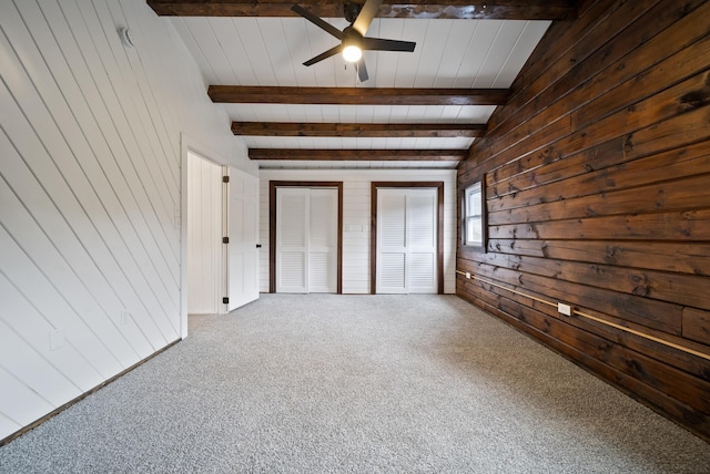 753 Sanborn Rd, Sanbornton, NH 03269 - unfurnished bedroom featuring beamed ceiling, wooden walls, carpet, and two closets