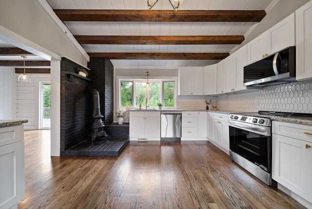 753 Sanborn Rd, Sanbornton, NH 03269 - kitchen with appliances with stainless steel finishes, beamed ceiling, a wood stove, backsplash, and white cabinetry