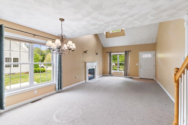 10 Hadleigh Rd, Windham, NH 03087 - unfurnished living room with vaulted ceiling, baseboards, carpet floors, a chandelier, and a high end fireplace