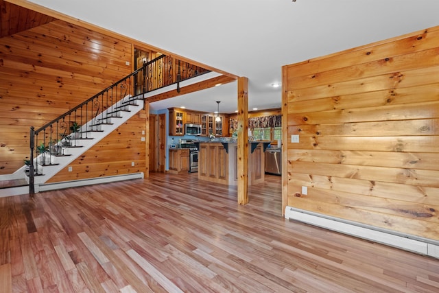 57 Westview Dr Unit 41 40, Haverhill, NH 03785 - unfurnished living room featuring a baseboard radiator, stairs, light wood-type flooring, a baseboard heating unit, and wood walls