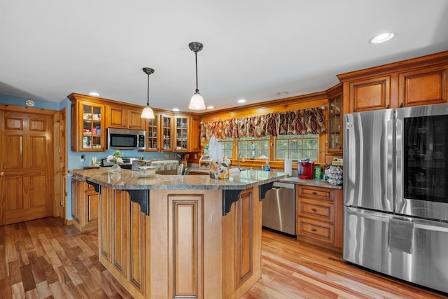 57 Westview Dr Unit 41 40, Haverhill, NH 03785 - kitchen featuring appliances with stainless steel finishes, brown cabinets, light wood-style flooring, stone countertops, and glass insert cabinets