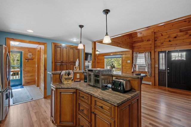 57 Westview Dr Unit 41 40, Haverhill, NH 03785 - kitchen featuring brown cabinets, freestanding refrigerator, light wood-type flooring, wood walls, and recessed lighting