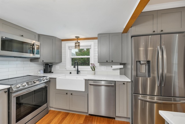 47 Foch St, Manchester, NH 03104 - kitchen with stainless steel appliances, gray cabinetry, a sink, and decorative backsplash