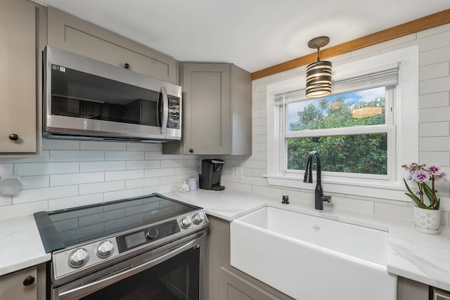 47 Foch St, Manchester, NH 03104 - kitchen with stainless steel appliances, gray cabinets, a sink, backsplash, and pendant lighting