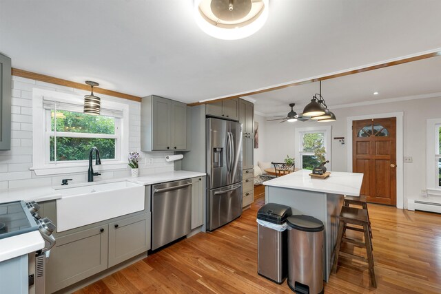 47 Foch St, Manchester, NH 03104 - kitchen featuring appliances with stainless steel finishes, a sink, gray cabinetry, light wood-style flooring, and backsplash