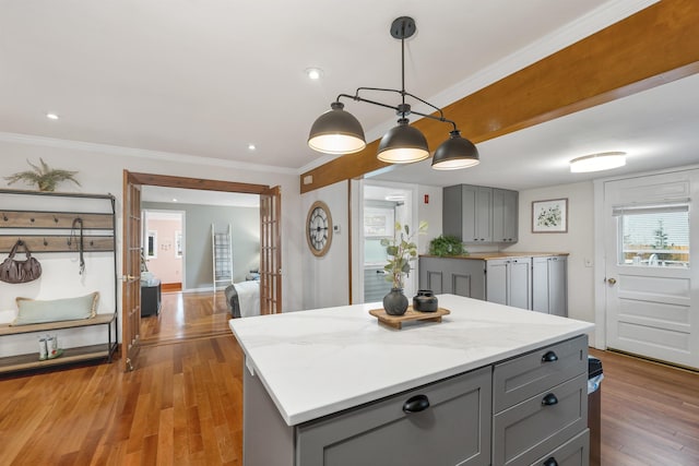47 Foch St, Manchester, NH 03104 - kitchen with gray cabinets, light wood-type flooring, crown molding, hanging light fixtures, and a kitchen island