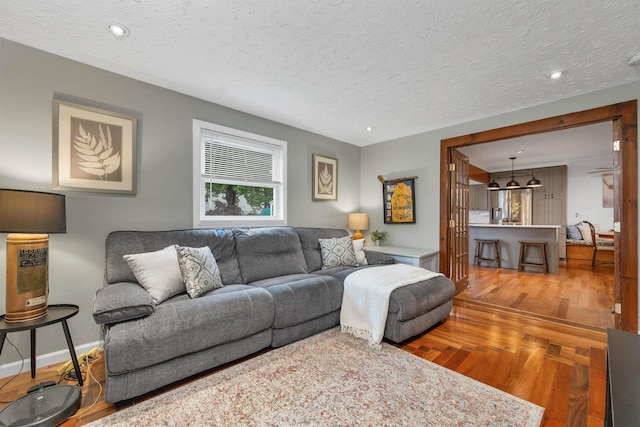 47 Foch St, Manchester, NH 03104 - living area with wood finished floors, a textured ceiling, recessed lighting, and baseboards