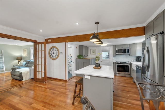 47 Foch St, Manchester, NH 03104 - kitchen with appliances with stainless steel finishes, gray cabinets, baseboards, a center island, and light wood-style flooring