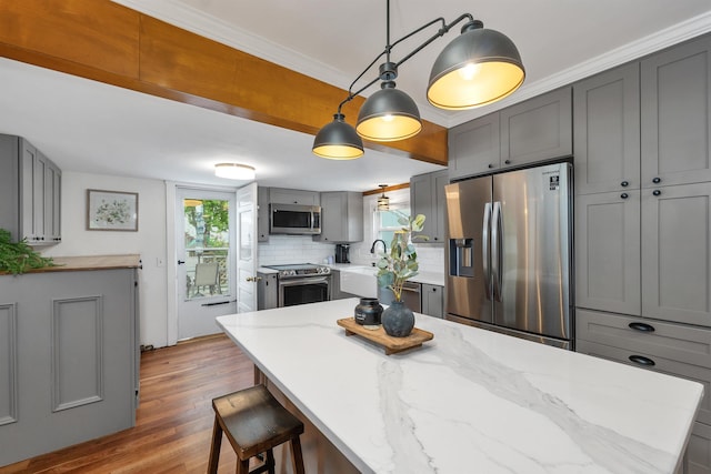 47 Foch St, Manchester, NH 03104 - kitchen featuring stainless steel appliances, gray cabinetry, plenty of natural light, and wood finished floors
