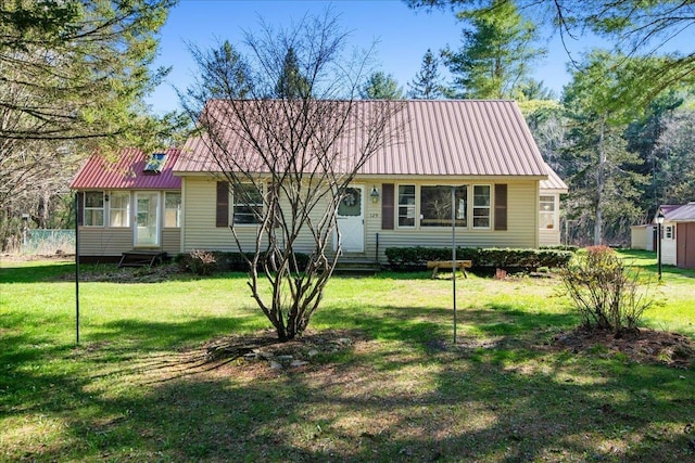 129 Camp Kiniya Rd, Colchester, VT 05446 - view of front of home featuring metal roof, entry steps, a front lawn, a sunroom, and an outdoor structure