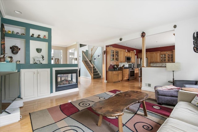 26 Pinnacle Dr, South Burlington, VT 05403 - living room featuring light wood-type flooring, stairs, ornamental molding, and a multi sided fireplace