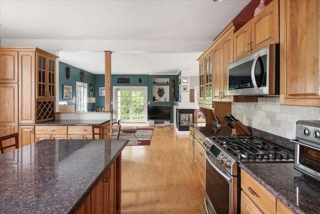 26 Pinnacle Dr, South Burlington, VT 05403 - kitchen featuring appliances with stainless steel finishes, light wood-style floors, decorative backsplash, glass insert cabinets, and dark stone countertops
