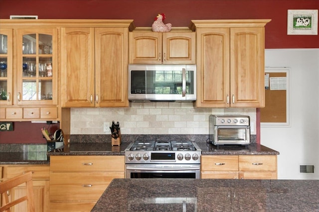 26 Pinnacle Dr, South Burlington, VT 05403 - kitchen with appliances with stainless steel finishes, glass insert cabinets, tasteful backsplash, dark stone counters, and light brown cabinetry