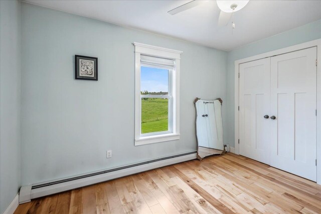 3352 Watertower Rd, Berkshire, VT 05450 - unfurnished bedroom with a baseboard heating unit, wood finished floors, a closet, and a ceiling fan