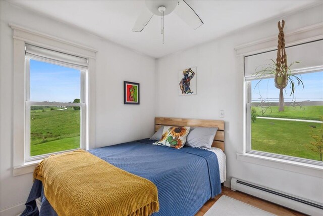 3352 Watertower Rd, Berkshire, VT 05450 - bedroom with baseboard heating, wood finished floors, and a ceiling fan