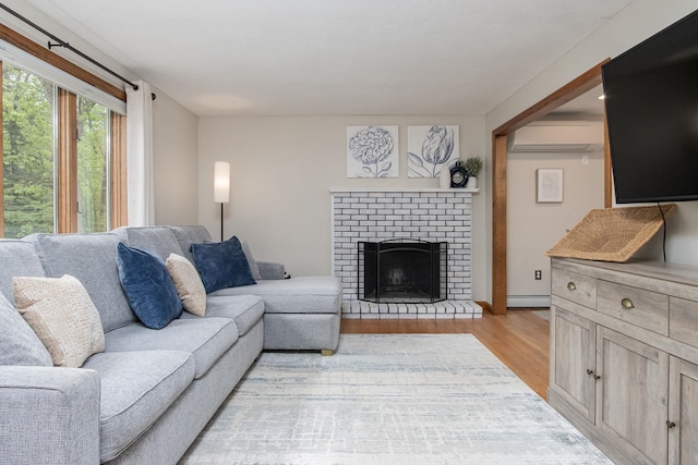 27 Grafton Dr, Bedford, NH 03110 - living area with light wood-type flooring, a wall unit AC, a baseboard radiator, and a brick fireplace