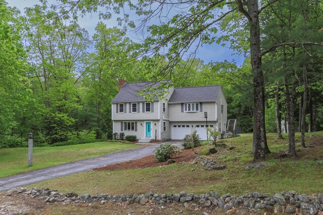27 Grafton Dr, Bedford, NH 03110 - colonial home featuring asphalt driveway, a chimney, a garage, a front yard, and a shingled roof