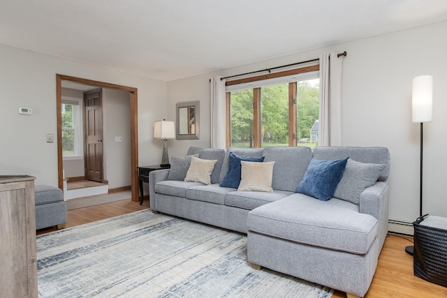 27 Grafton Dr, Bedford, NH 03110 - living area with wood finished floors, healthy amount of natural light, and a baseboard radiator