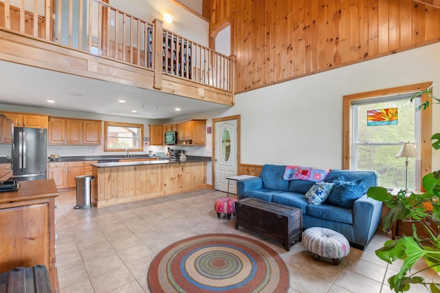 174 Sky View Rd, Stratford, NH 03590 - living room with light tile patterned floors, a high ceiling, wood walls, recessed lighting, and wainscoting