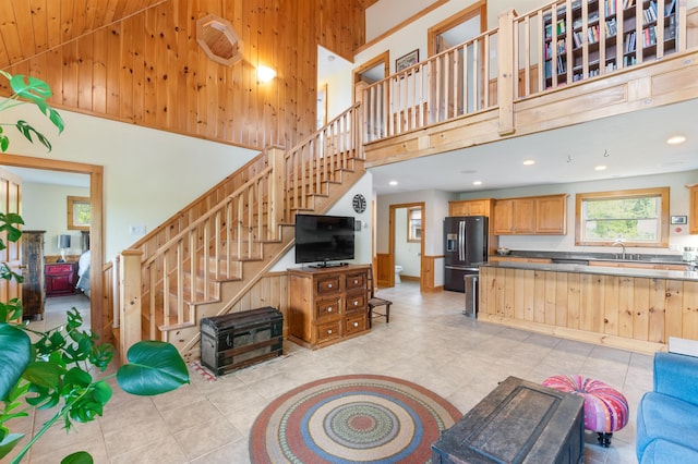 174 Sky View Rd, Stratford, NH 03590 - living room with a towering ceiling, stairway, light tile patterned floors, recessed lighting, and wood walls